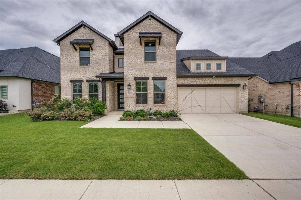 2813 Walker Way, Northlake, TX 76247 Two-story brick facade residence featuring a dark shingle roof, integrated two-car garage, and dormer window detail
