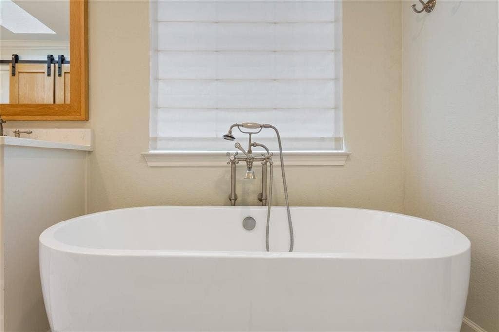 402 Shadow Mountain Drive, Woodway, TX 76712 Upstairs freestanding soaking tub with brushed nickel floor-mounted faucet and handheld shower