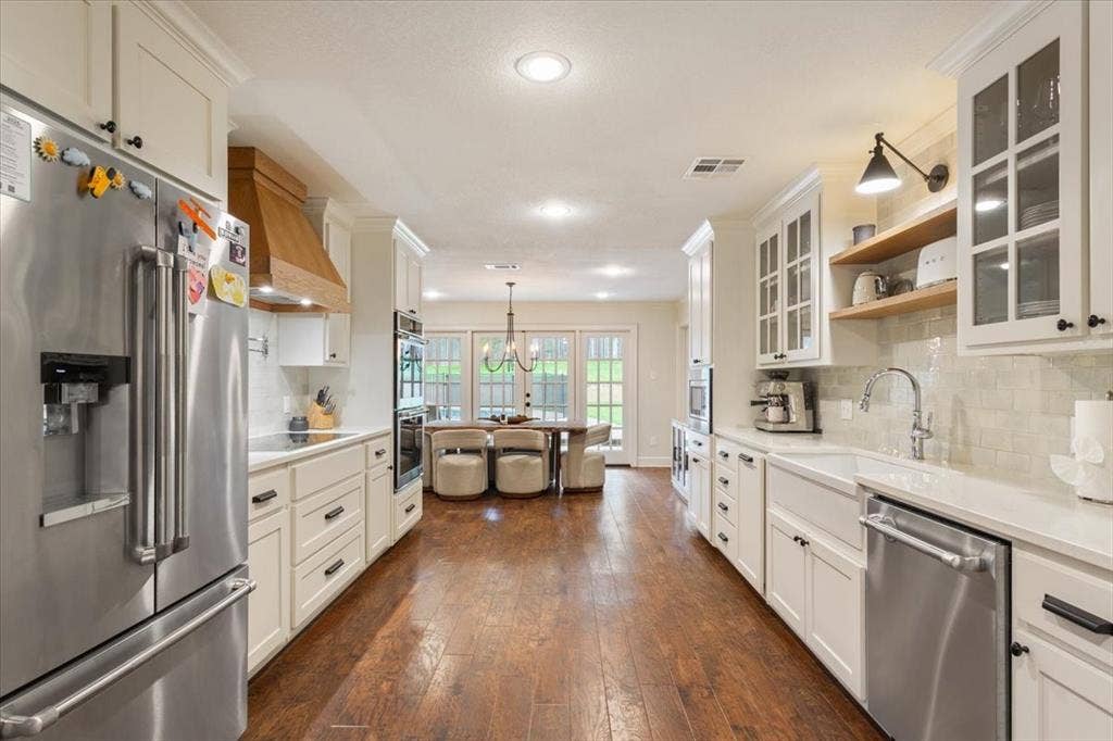 402 Shadow Mountain Drive, Woodway, TX 76712 Kitchen featuring hardwood flooring, white cabinetry, stainless steel appliances, a farmhouse sink, and light-toned countertops