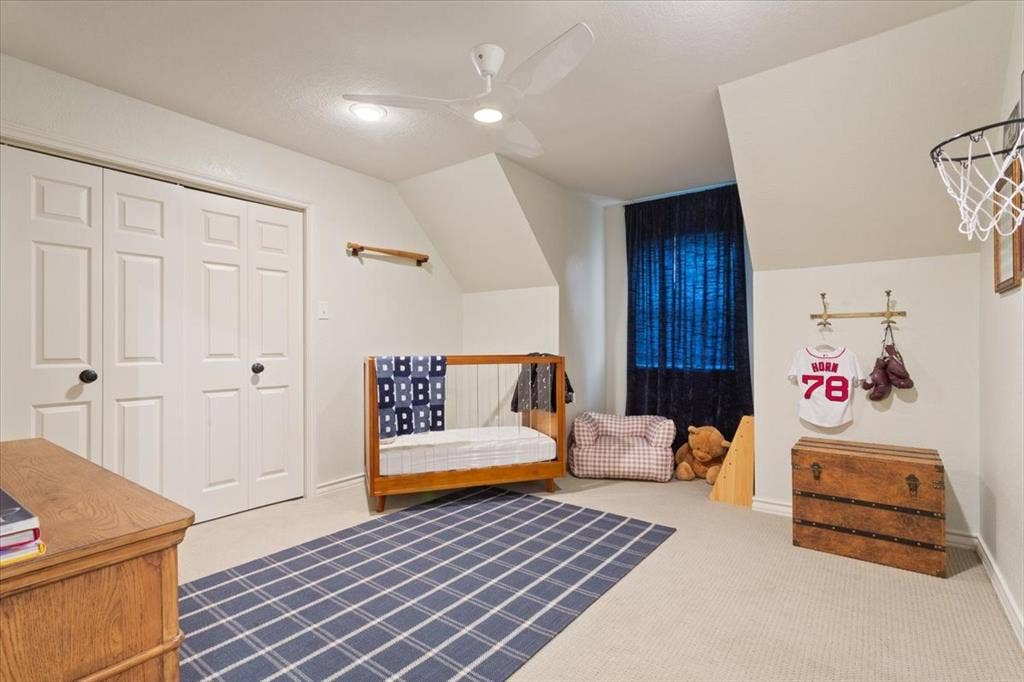 402 Shadow Mountain Drive, Woodway, TX 76712 Upstairs carpeted room featuring a ceiling fan with integrated lighting, a double bi-fold closet, and a window with dark curtains