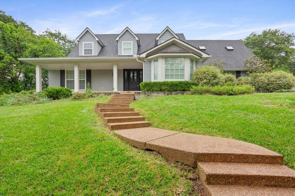 402 Shadow Mountain Drive, Woodway, TX 76712 Two-story residence featuring a covered front porch with white pillars, a bay window, and dormer windows