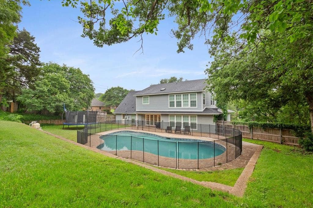 402 Shadow Mountain Drive, Woodway, TX 76712 Spacious backyard featuring a fenced-in swimming pool with an integrated patio, extensive green lawn, and mature perimeter trees