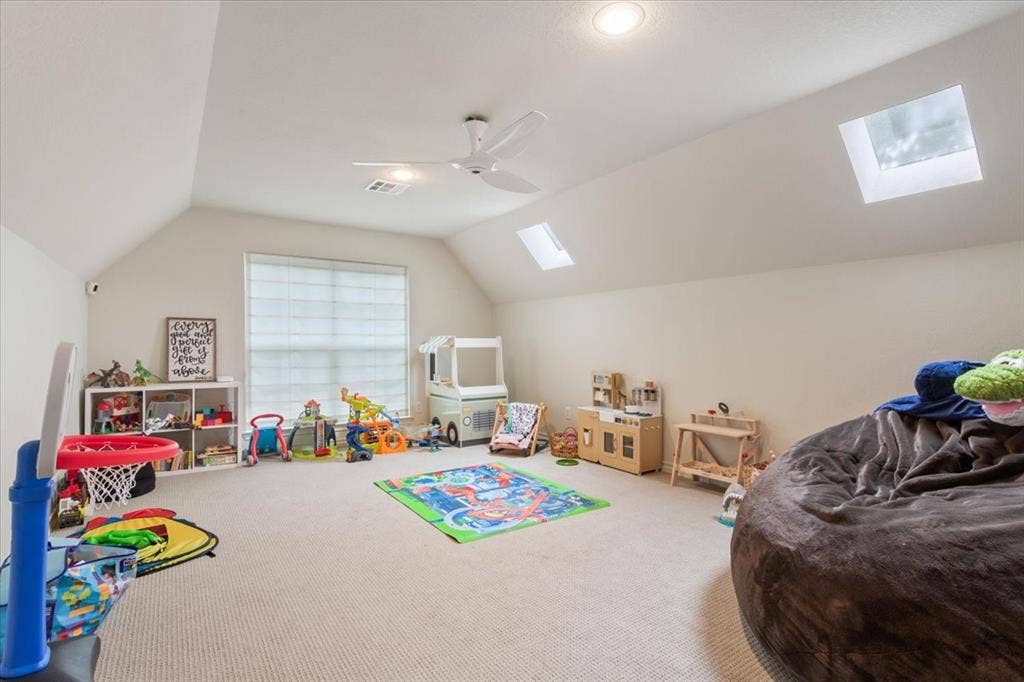 402 Shadow Mountain Drive, Woodway, TX 76712 Upstairs carpeted room with a vaulted ceiling, multiple skylights, and a window with blinds