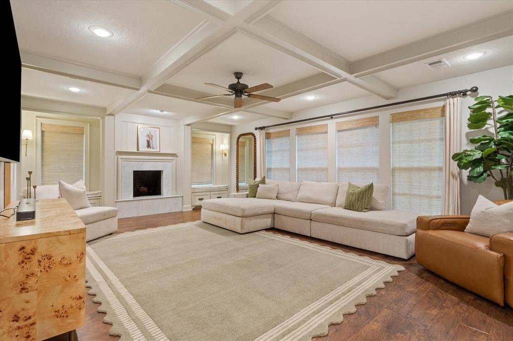 402 Shadow Mountain Drive, Woodway, TX 76712 Spacious living area featuring a coffered ceiling, wood-finish flooring, and a fireplace with a stone surround