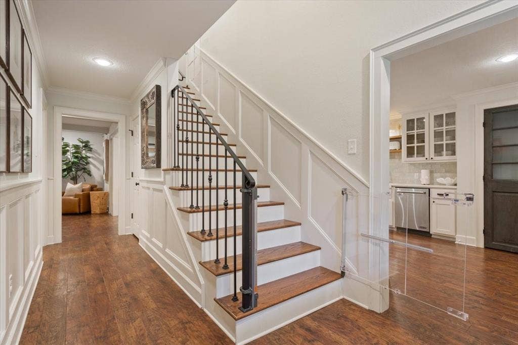 402 Shadow Mountain Drive, Woodway, TX 76712 Staircase featuring wood treads, white risers, and wrought iron balusters with a dark handrail