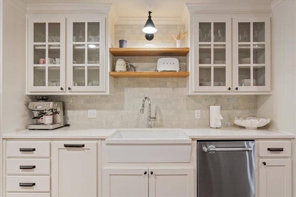 402 Shadow Mountain Drive, Woodway, TX 76712 White shaker cabinetry with glass-front upper cabinets, a white farmhouse sink, and stainless steel dishwasher