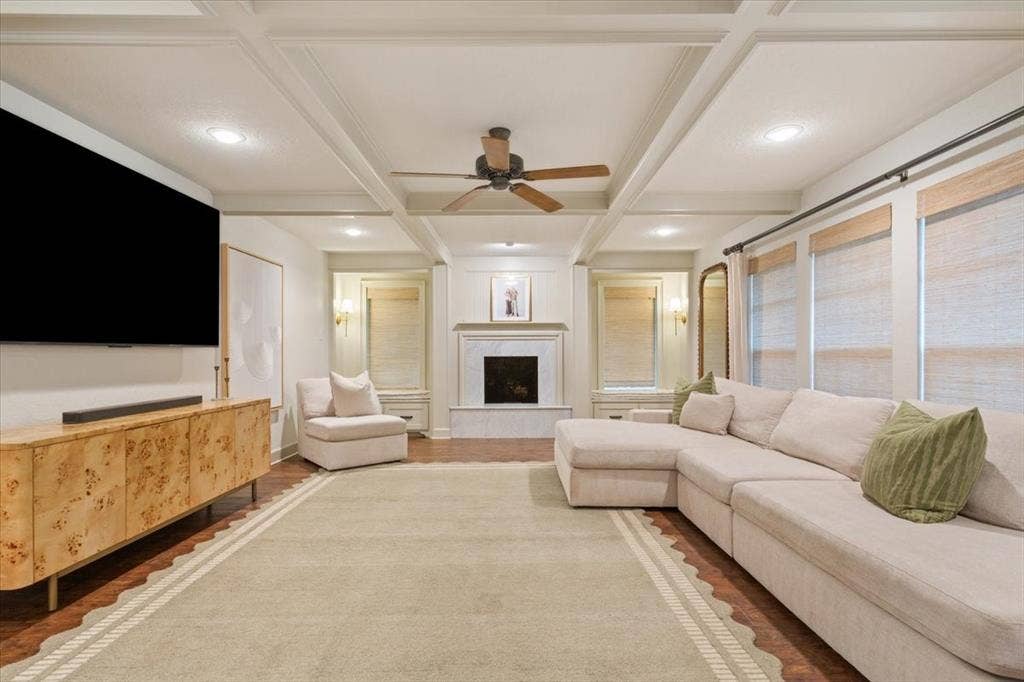 402 Shadow Mountain Drive, Woodway, TX 76712 Living area featuring hardwood flooring, a coffered ceiling with recessed lighting and a ceiling fan, a fireplace with a stone surround and mantel, and multiple windows with roller shades