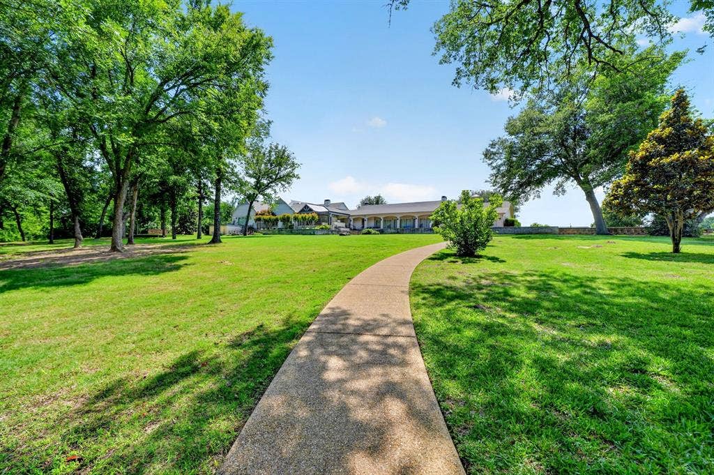 1901 Rose Point, Athens, TX 75752 Spacious lawn with a winding concrete pathway, mature trees, and landscaping