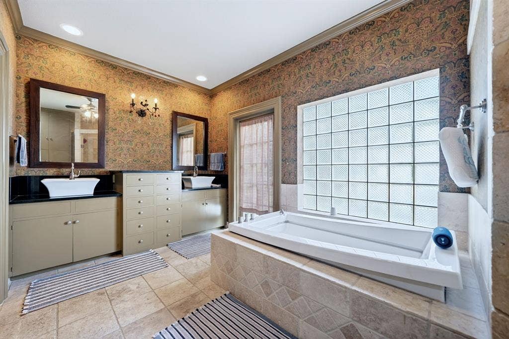 1901 Rose Point, Athens, TX 75752 Soaking tub with tile surround, glass block window, dual vanity with vessel sinks, built-in cabinetry, and tile flooring