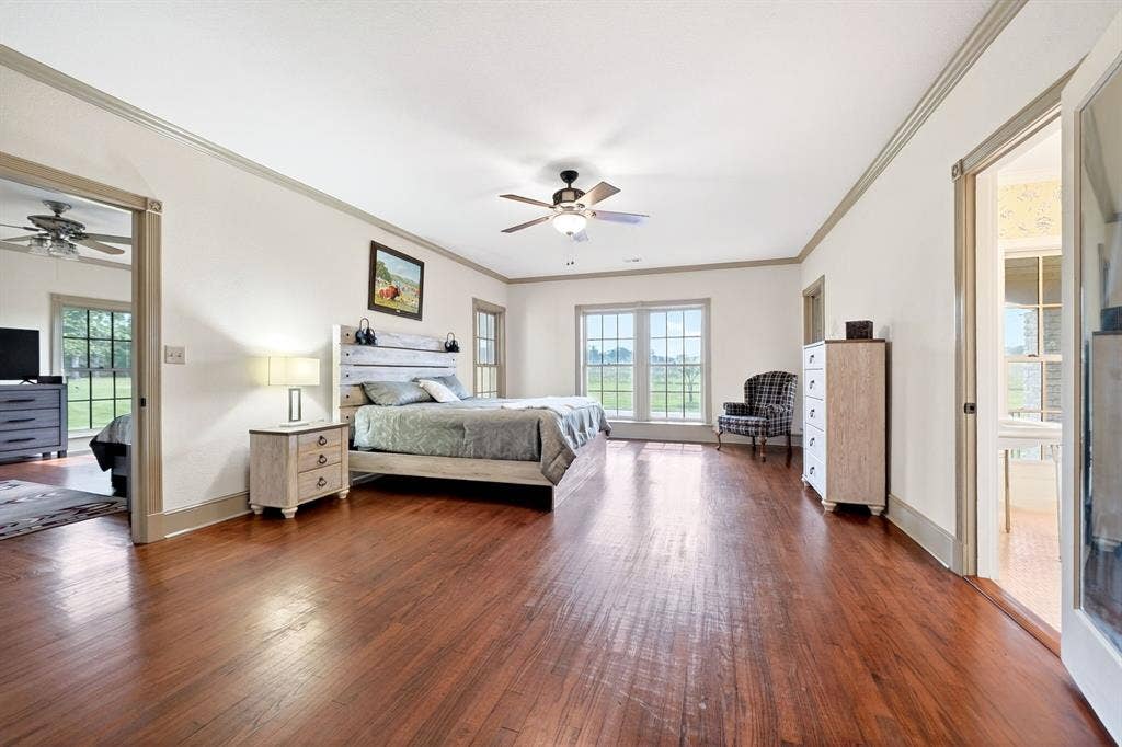 1901 Rose Point, Athens, TX 75752 Spacious room featuring rich wood-finish flooring, a ceiling fan, and white walls with gray trim