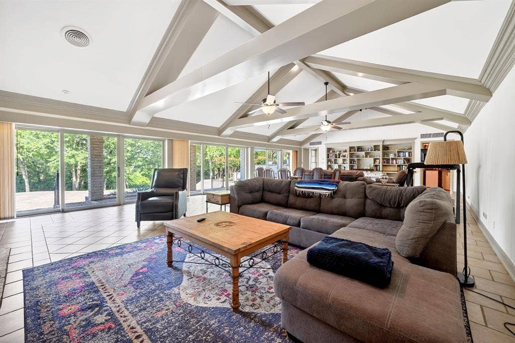 1901 Rose Point, Athens, TX 75752 Expansive living area featuring a vaulted ceiling with exposed beams, tile flooring, and a wall of sliding glass doors