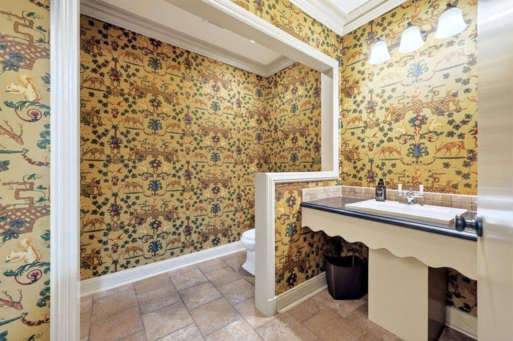 1901 Rose Point, Athens, TX 75752 Powder room featuring detailed patterned wallpaper, a bespoke vanity with an integrated sink, a dark countertop, and a tiled backsplash