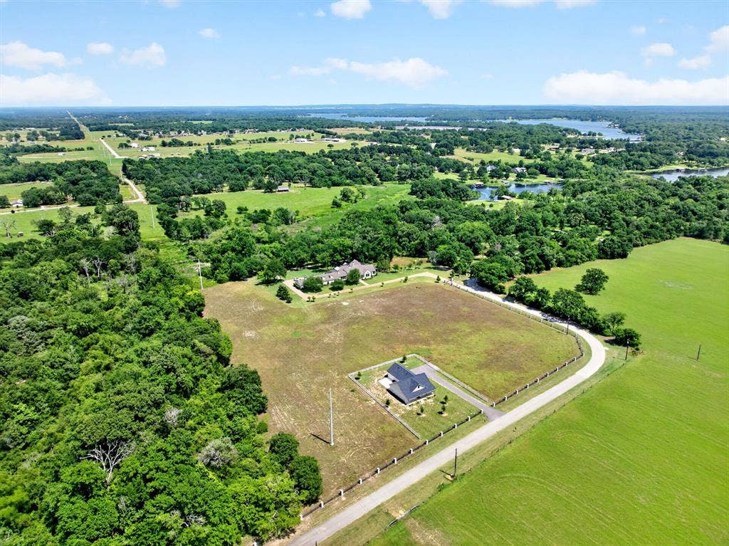1901 Rose Point, Athens, TX 75752 Spacious property featuring a contemporary residence with a dark gray roof and light siding