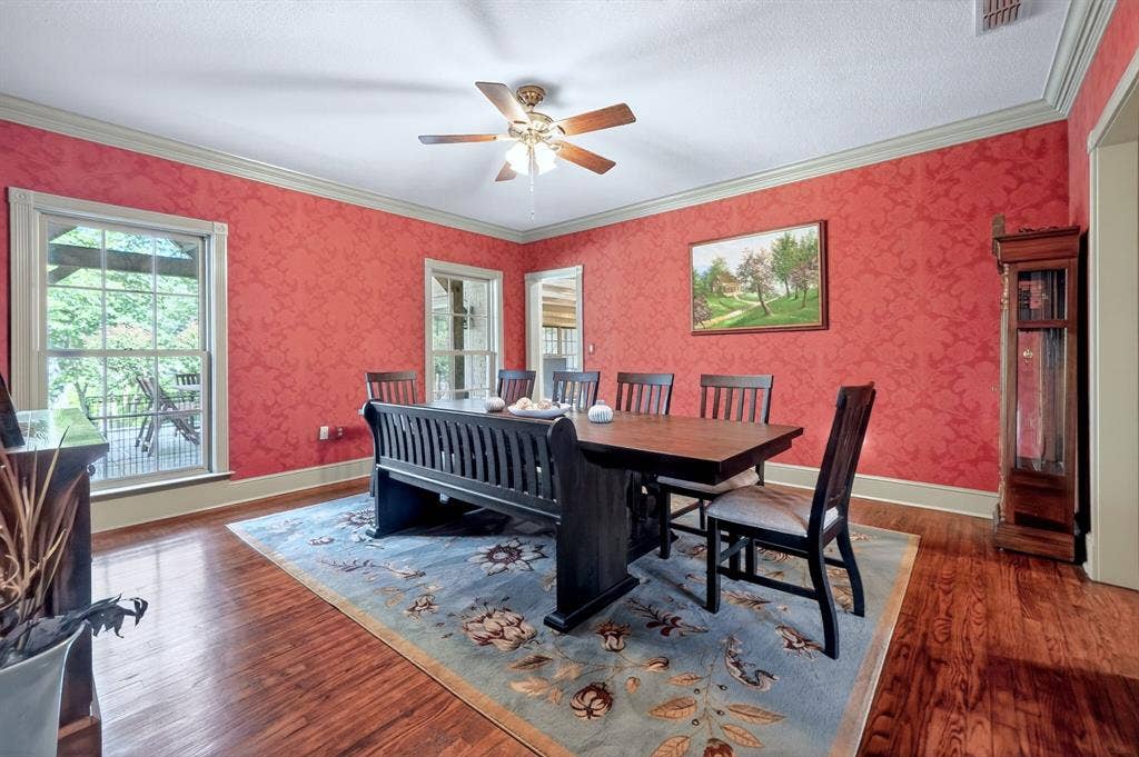 1901 Rose Point, Athens, TX 75752 Formal dining space featuring wood-finish flooring, patterned red wall coverings, and a ceiling fan with integrated lighting