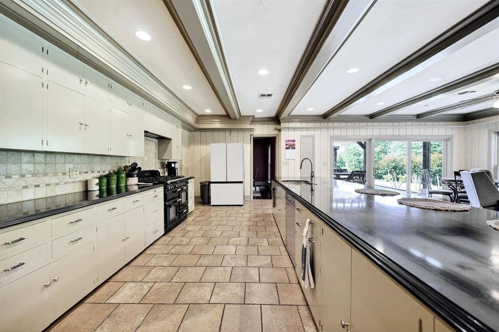 1901 Rose Point, Athens, TX 75752 Spacious kitchen featuring extensive cabinetry, dark countertops, tiled flooring, recessed lighting, and a large central island with an integrated sink