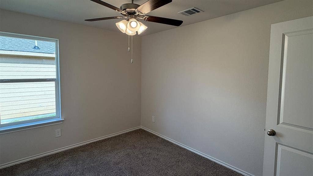 3013 Hidden Valley Drive, Lindale, TX 75771 Room featuring neutral wall tones, carpet flooring, a window with horizontal blinds, a ceiling fan with integrated lighting, and a paneled door with a brushed nickel knob