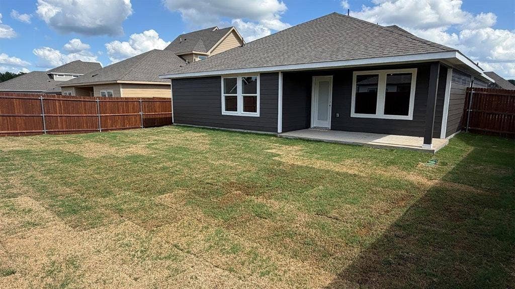 3013 Hidden Valley Drive, Lindale, TX 75771 Expansive backyard featuring a privacy fence, concrete patio, and dark-toned siding