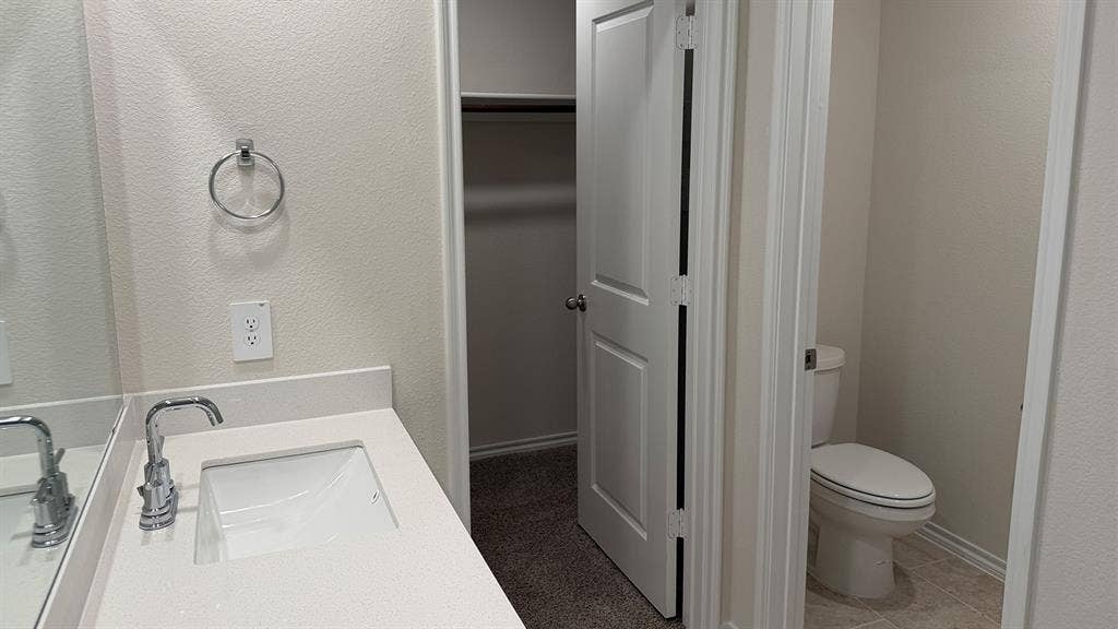 3013 Hidden Valley Drive, Lindale, TX 75771 Bathroom vanity featuring a polished chrome faucet, under-mount sink, and light-toned countertop