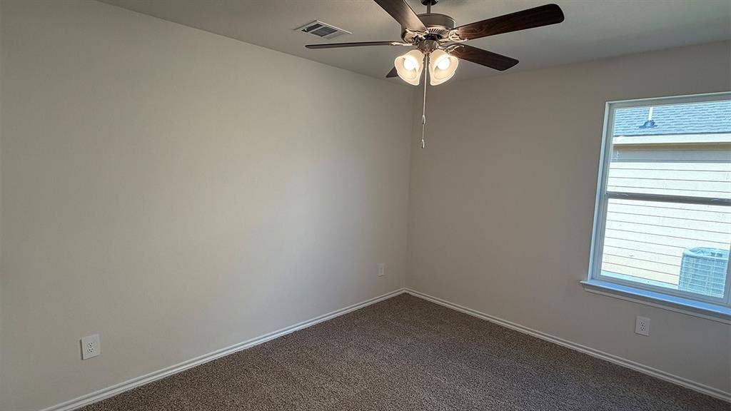 3013 Hidden Valley Drive, Lindale, TX 75771 Carpeted room featuring a ceiling fan with integrated lighting, a double-pane window, and light-toned walls