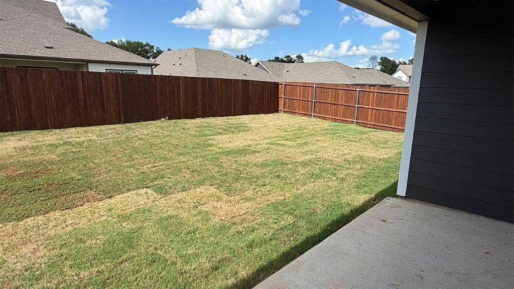 3013 Hidden Valley Drive, Lindale, TX 75771 Spacious backyard featuring a new privacy fence, an integrated concrete patio, and a blend of green and established lawn