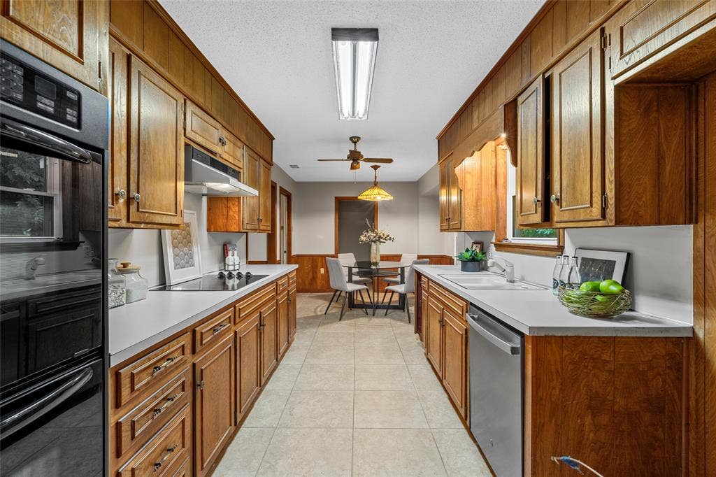 3301 Loma Vista Drive, Waco, TX 76708 Galley kitchen featuring wood cabinetry, white countertops, a built-in oven, and a double basin sink