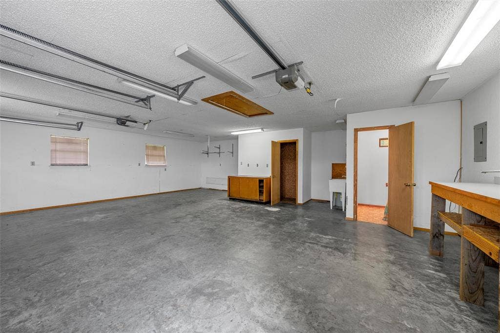 3301 Loma Vista Drive, Waco, TX 76708 Spacious garage featuring a concrete floor, multiple windows, built-in cabinetry, and a utility sink