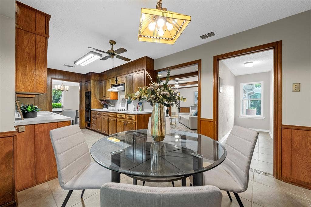 3301 Loma Vista Drive, Waco, TX 76708 Kitchen featuring wood-paneling, built-in double ovens, and a ceiling fan with integrated lighting