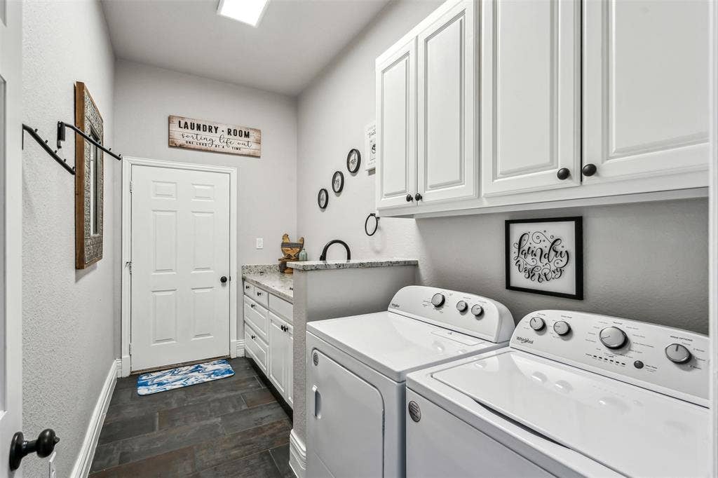 2100 Gene Court, Granbury, TX 76048 Dedicated laundry room featuring dark tile flooring, white shaker cabinetry, a granite-finish countertop with a built-in sink, and overhead recessed lighting