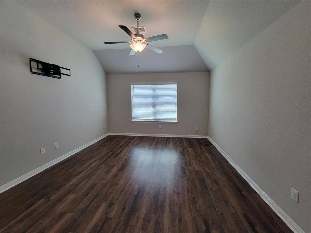 1106 Placid Circle, Waco, TX 76706 Spacious interior room featuring wood-finish flooring, a vaulted ceiling, and a ceiling fan with integrated lighting