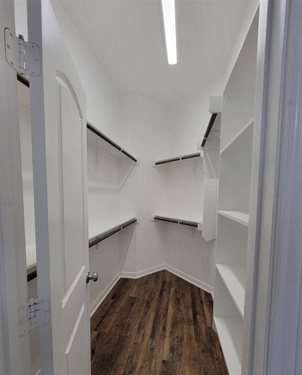 1106 Placid Circle, Waco, TX 76706 Spacious walk-in closet featuring white built-in shelving, hanging rods, and wood-finish flooring
