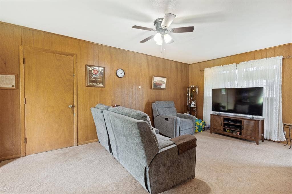 3013 Margo Drive, Mesquite, TX 75150 Living space featuring wood paneling, light-colored carpeting, a white ceiling, and a ceiling fan with integrated lighting