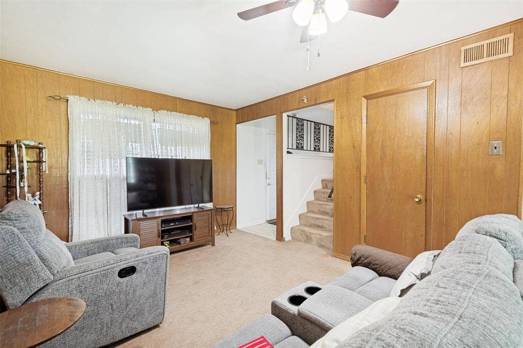 3013 Margo Drive, Mesquite, TX 75150 Living area featuring wood-paneled walls and carpeted flooring