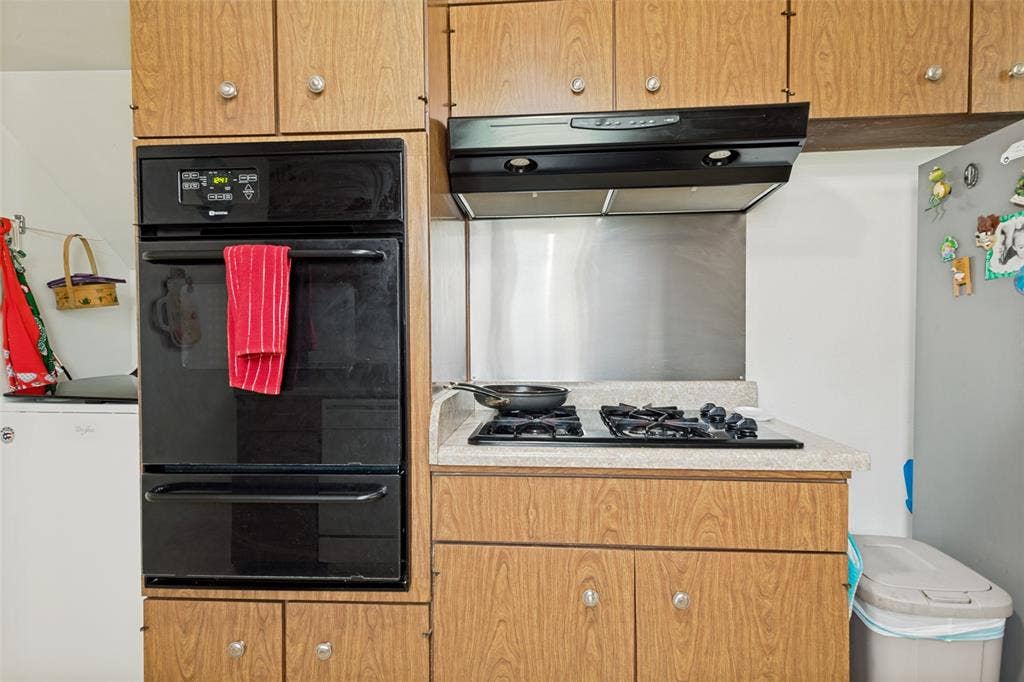 3013 Margo Drive, Mesquite, TX 75150 Kitchen featuring wood-finish cabinetry, a built-in wall oven, and a gas cooktop with an overhead range hood