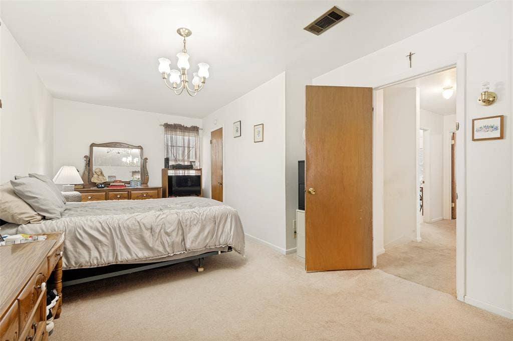 3013 Margo Drive, Mesquite, TX 75150 Carpeted room featuring a ceiling-mounted chandelier light fixture and a wood-panel interior door