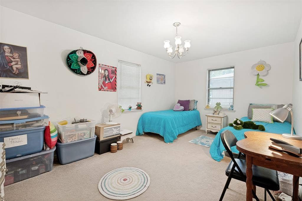 3013 Margo Drive, Mesquite, TX 75150 Bright room featuring a ceiling-mounted chandelier, carpeted flooring, and two windows providing natural light
