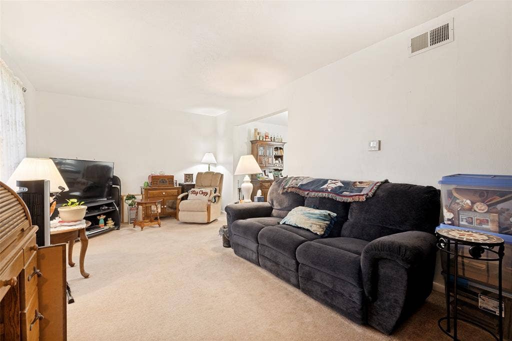 3013 Margo Drive, Mesquite, TX 75150 Carpeted living area featuring light-toned walls and an overhead air vent
