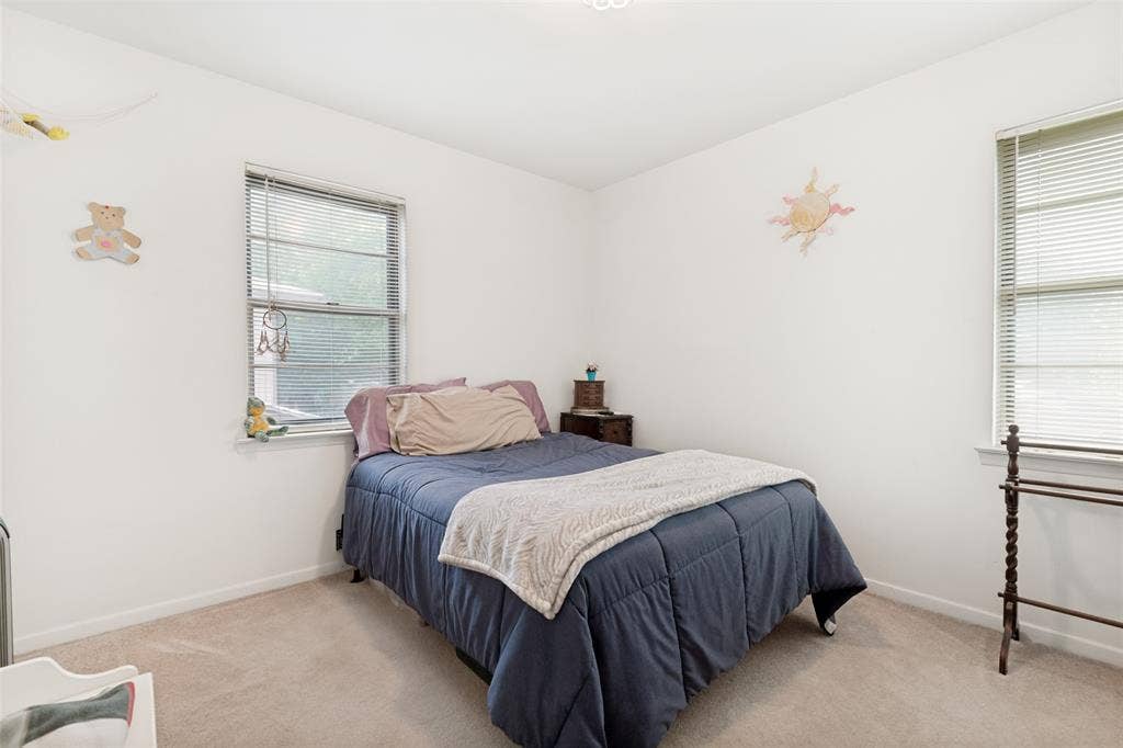 3013 Margo Drive, Mesquite, TX 75150 Carpeted room featuring two windows with horizontal blinds, white walls, and a ceiling light fixture