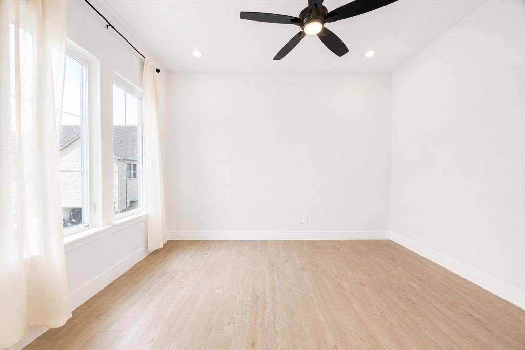 11965 Brubaker Drive, Frisco, TX 75033 Bright room featuring light wood-finish flooring, white walls, and a black ceiling fan with integrated lighting