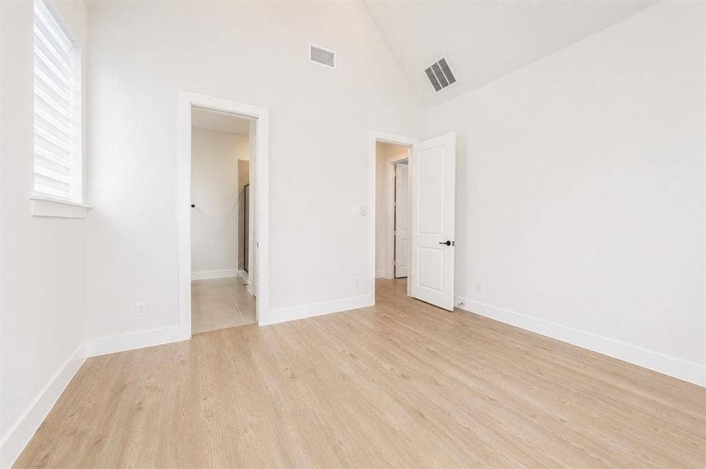 11965 Brubaker Drive, Frisco, TX 75033 Room featuring vaulted ceilings, light wood-finish flooring, white walls, and a window with horizontal blinds