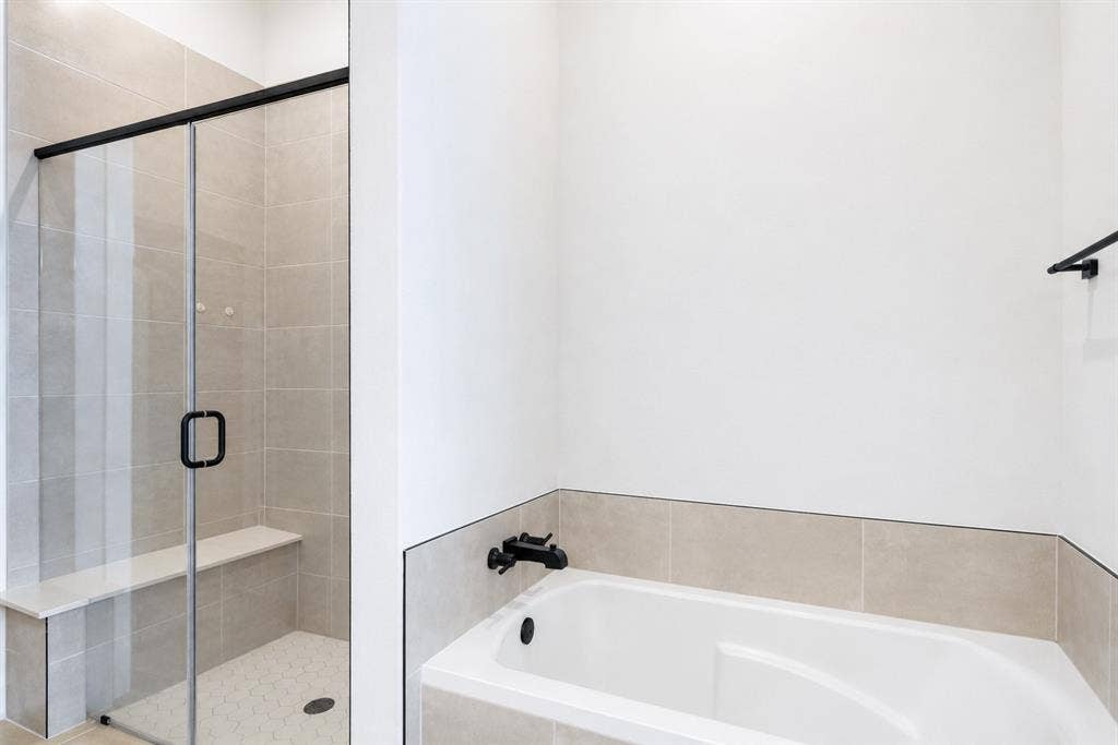 11965 Brubaker Drive, Frisco, TX 75033 Bathroom featuring a built-in tub with matte black fixtures, a tiled surround, and a glass-enclosed shower with a bench