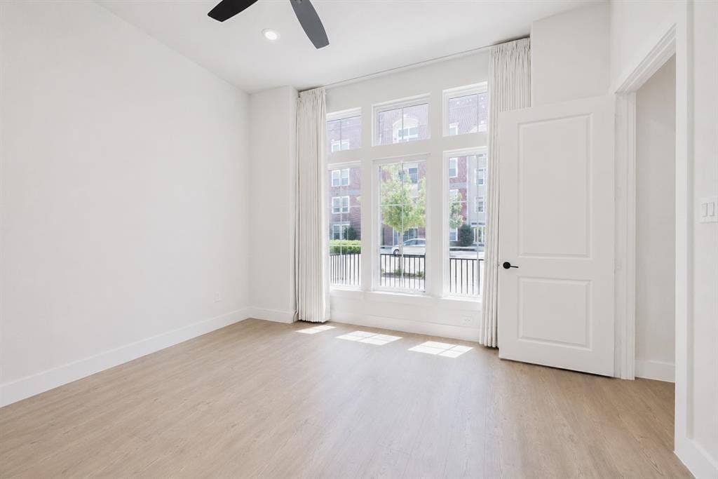 11965 Brubaker Drive, Frisco, TX 75033 Bright room featuring large multi-pane windows, wood-finish flooring, a ceiling fan, and white trim