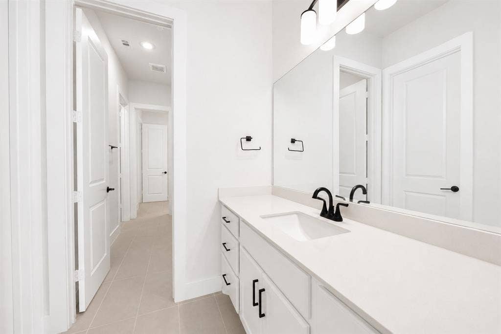 11965 Brubaker Drive, Frisco, TX 75033 Bathroom vanity featuring a light-colored countertop, integrated sink, and matte black faucet