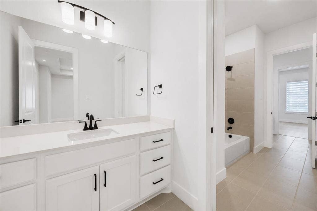 11965 Brubaker Drive, Frisco, TX 75033 Bathroom featuring a white vanity with an integrated sink, quartz countertop, and matte black fixtures