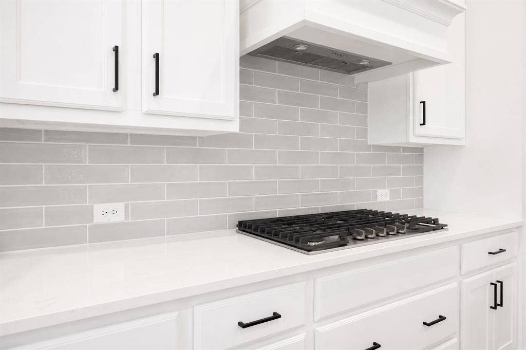 11965 Brubaker Drive, Frisco, TX 75033 Kitchen featuring a gas cooktop, light grey subway tile backsplash, white shaker-style cabinetry, white countertops, and matte black hardware