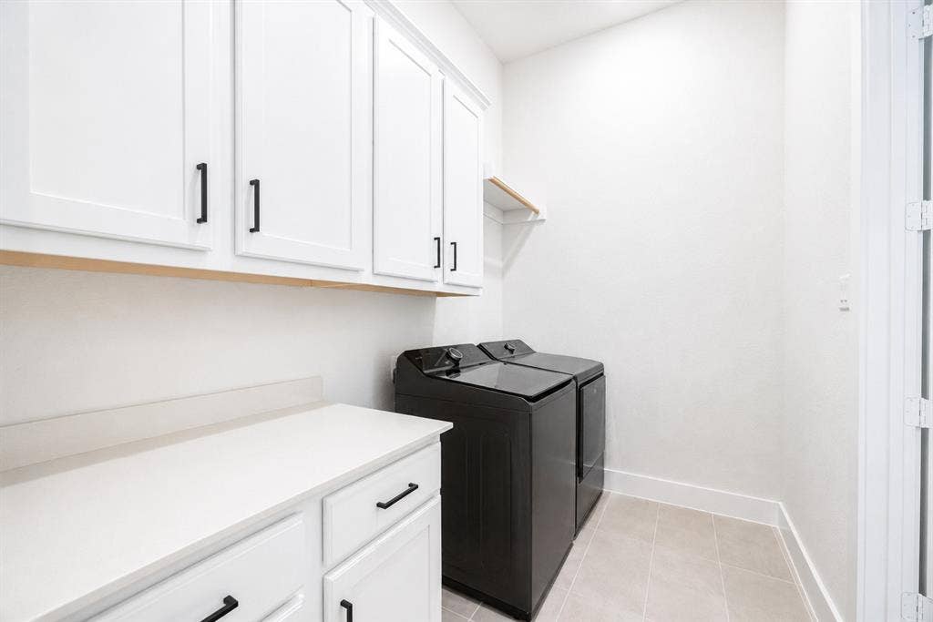 11965 Brubaker Drive, Frisco, TX 75033 Laundry area featuring white shaker-style cabinetry with black hardware, white countertop space, and light-toned floor tiling