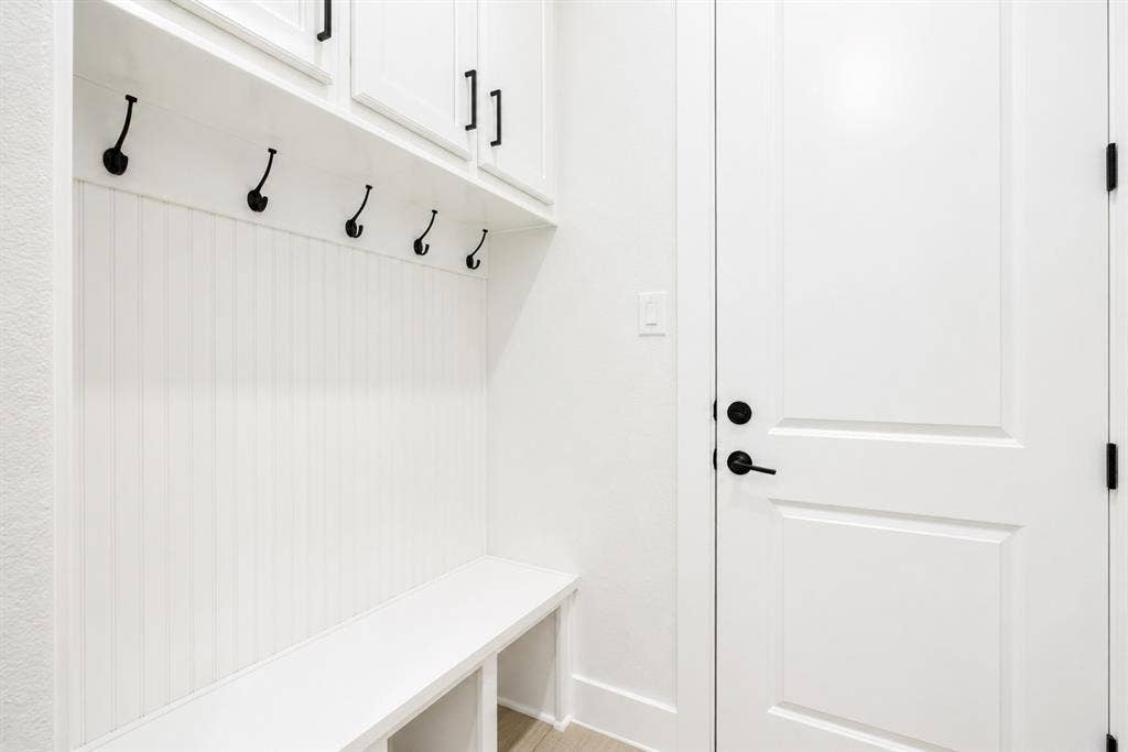 11965 Brubaker Drive, Frisco, TX 75033 Built-in mudroom bench with beadboard backing, overhead cabinetry, and black hardware