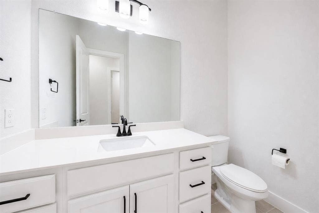 11965 Brubaker Drive, Frisco, TX 75033 Bathroom featuring a white vanity with an undermount sink, a white countertop, and black hardware