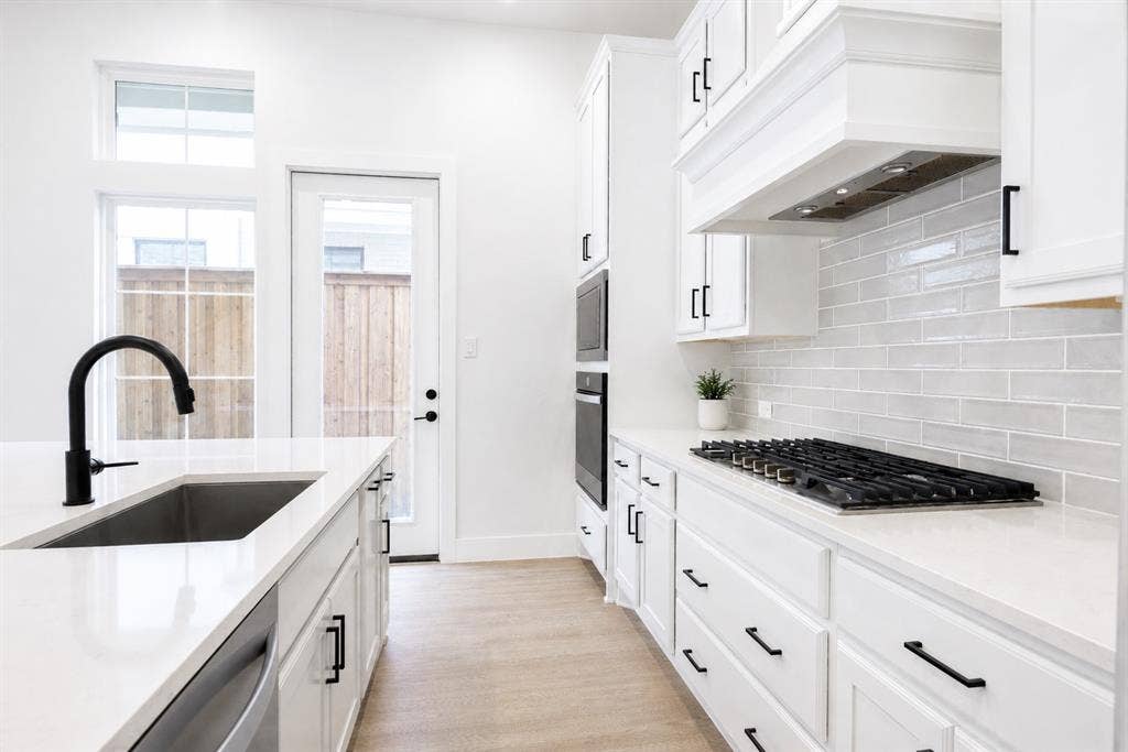 11965 Brubaker Drive, Frisco, TX 75033 Kitchen featuring white cabinetry, light-toned wood-finish flooring, a stainless steel undermount sink with a matte black faucet, and a gas cooktop