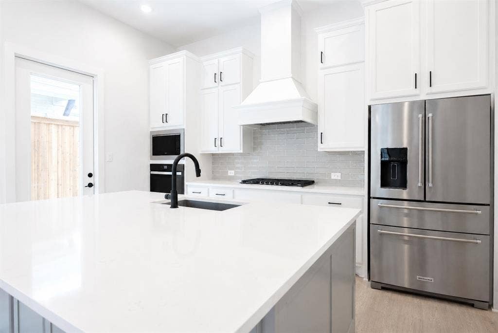 11965 Brubaker Drive, Frisco, TX 75033 Kitchen island featuring a white countertop with an undermount sink and matte black faucet