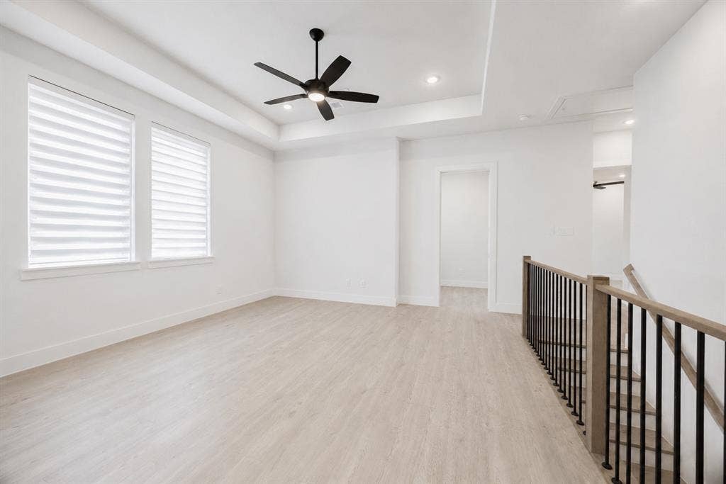 11965 Brubaker Drive, Frisco, TX 75033 Spacious upper-level room featuring wood-finish flooring, two large windows with blinds, a modern ceiling fan, and recessed lighting
